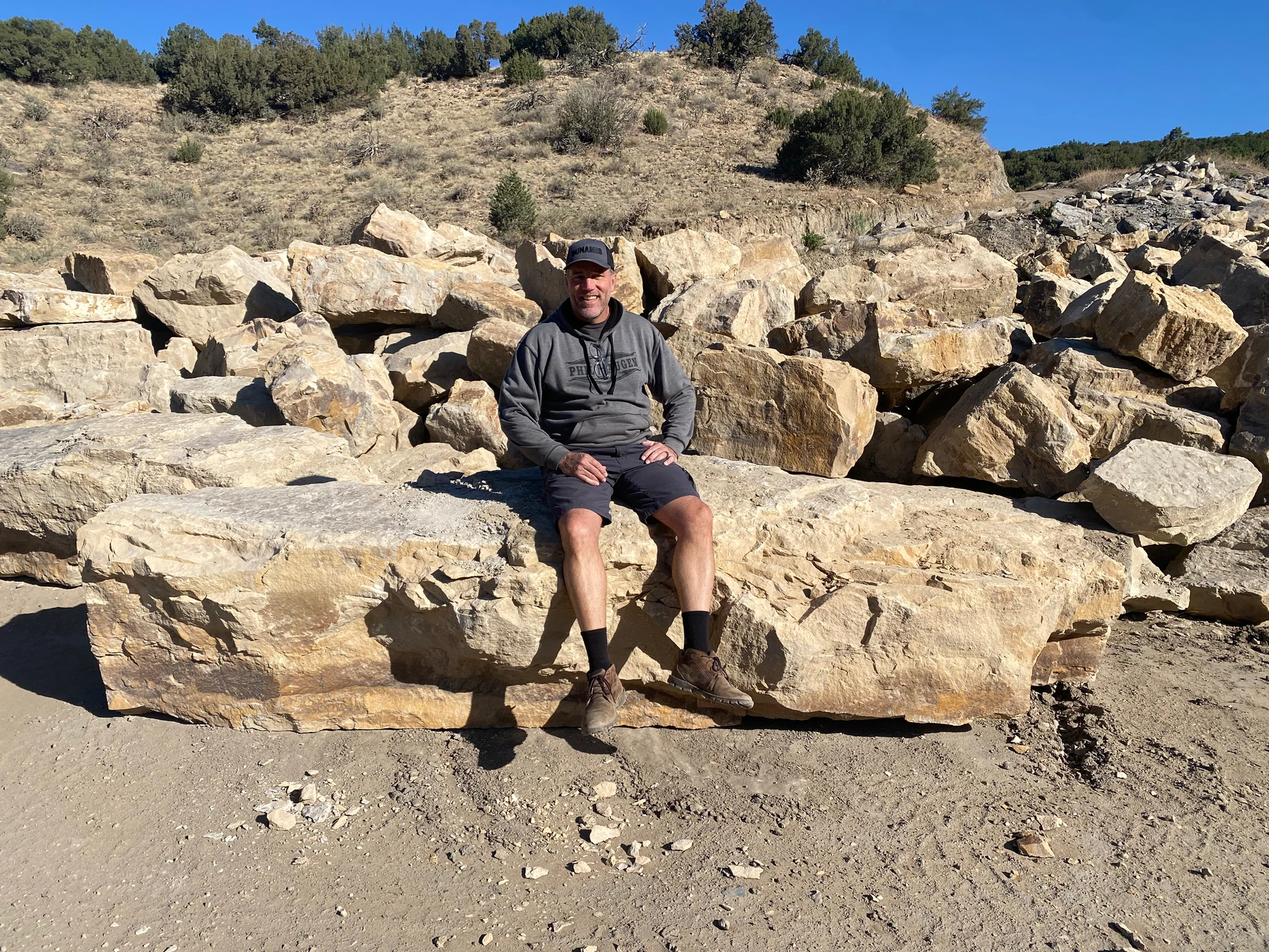 JD Crouse seated on large Breckenridge Gold sandstone slabs at the quarry